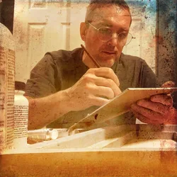 Thad painting on primed hardboard, brush in hand, working in the evening light.