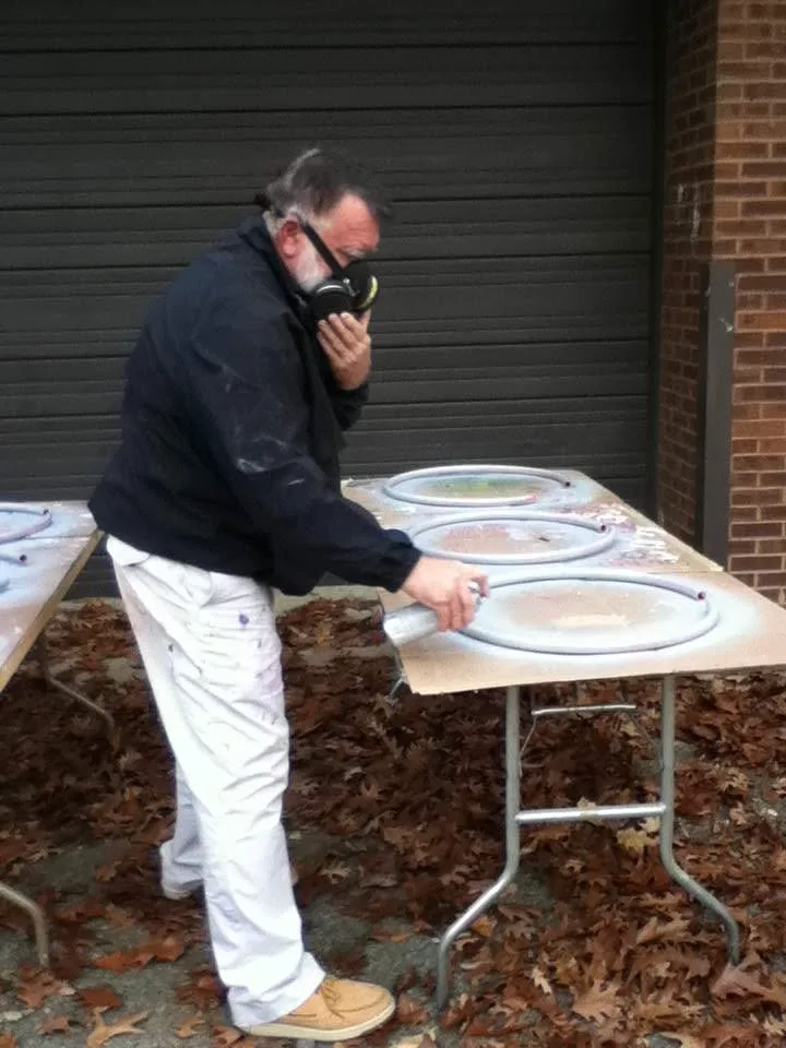 Chuck Baird wearing a respirator mask working on an art installation outdoors