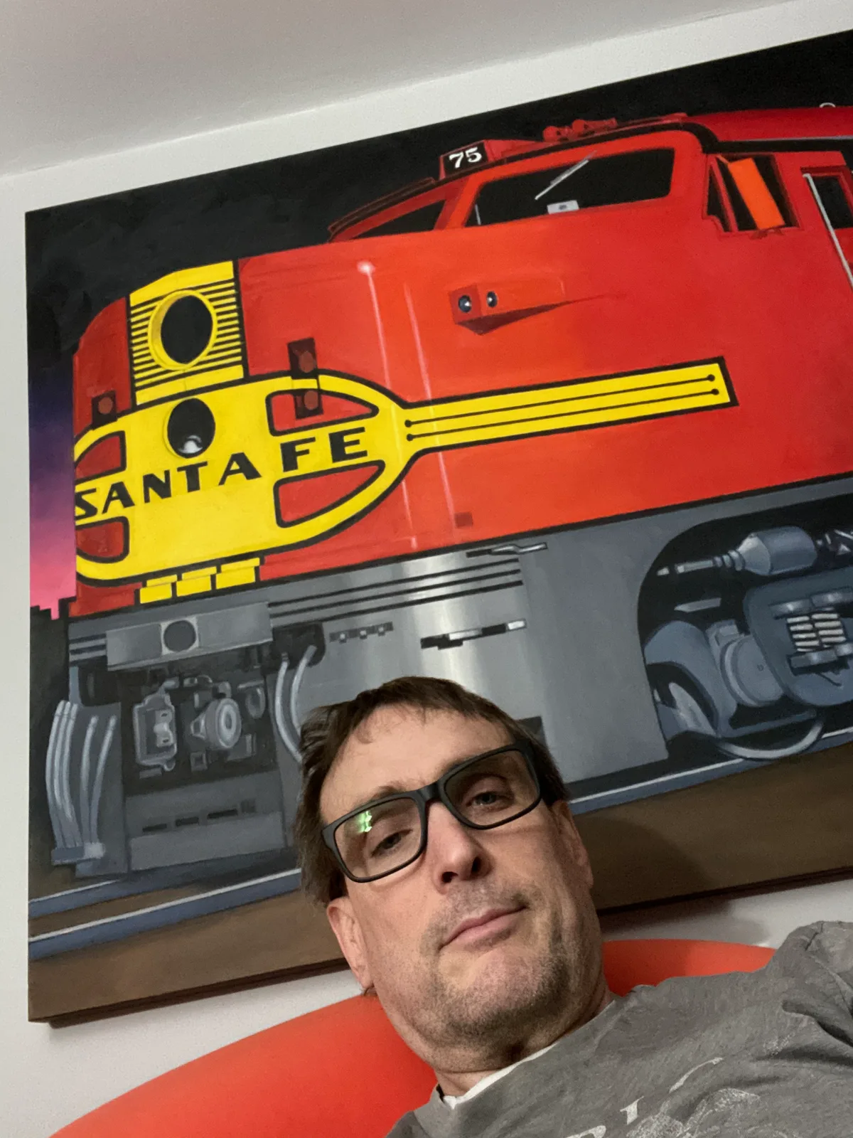 Thad sitting in front of Chuck Baird's Santa Fe locomotive painting
