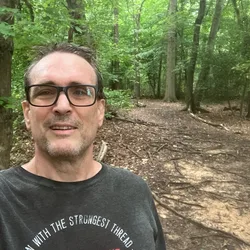 Thad taking a selfie on a wooded trail