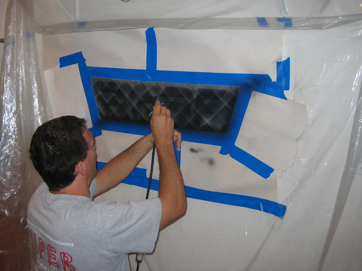 Thad airbrushing the background of the sign with the lettering masked off