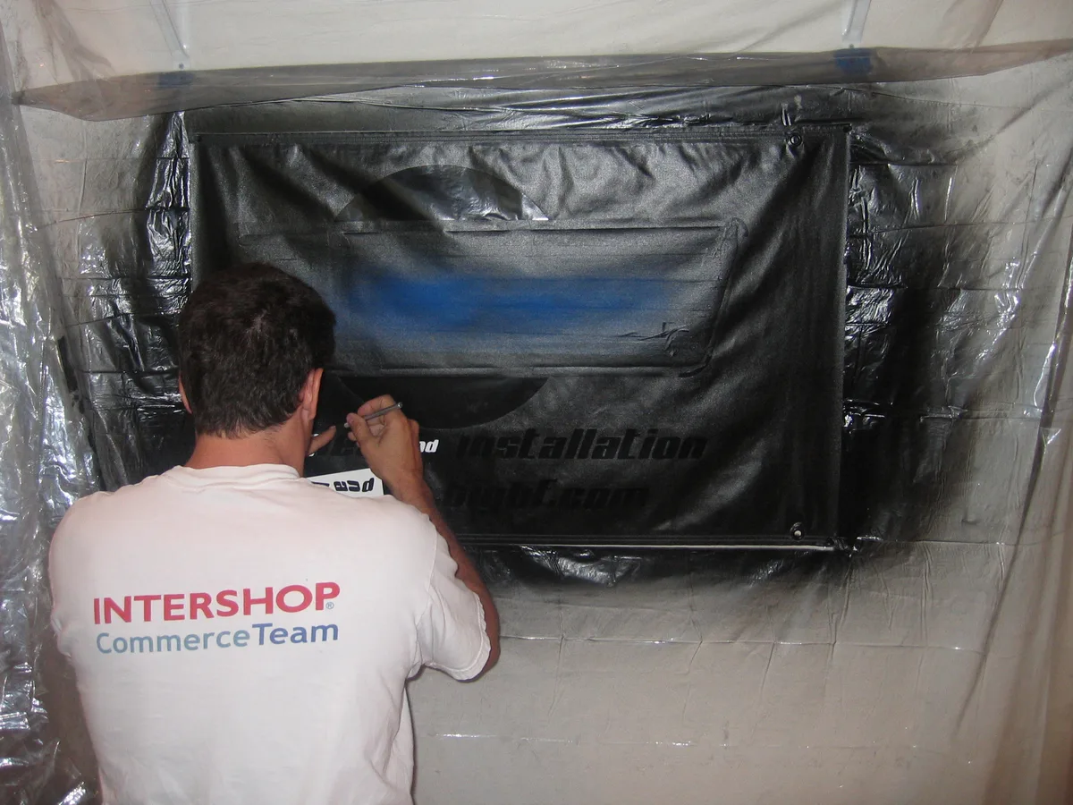 Peeling the masking tape and paper off the airbrushed sign