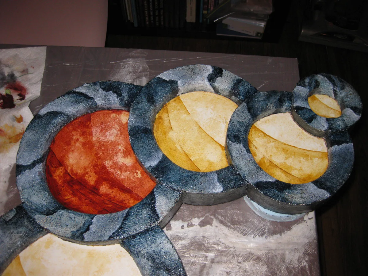 The circle representing the dried puddle, painted red, sits among the gold circles.