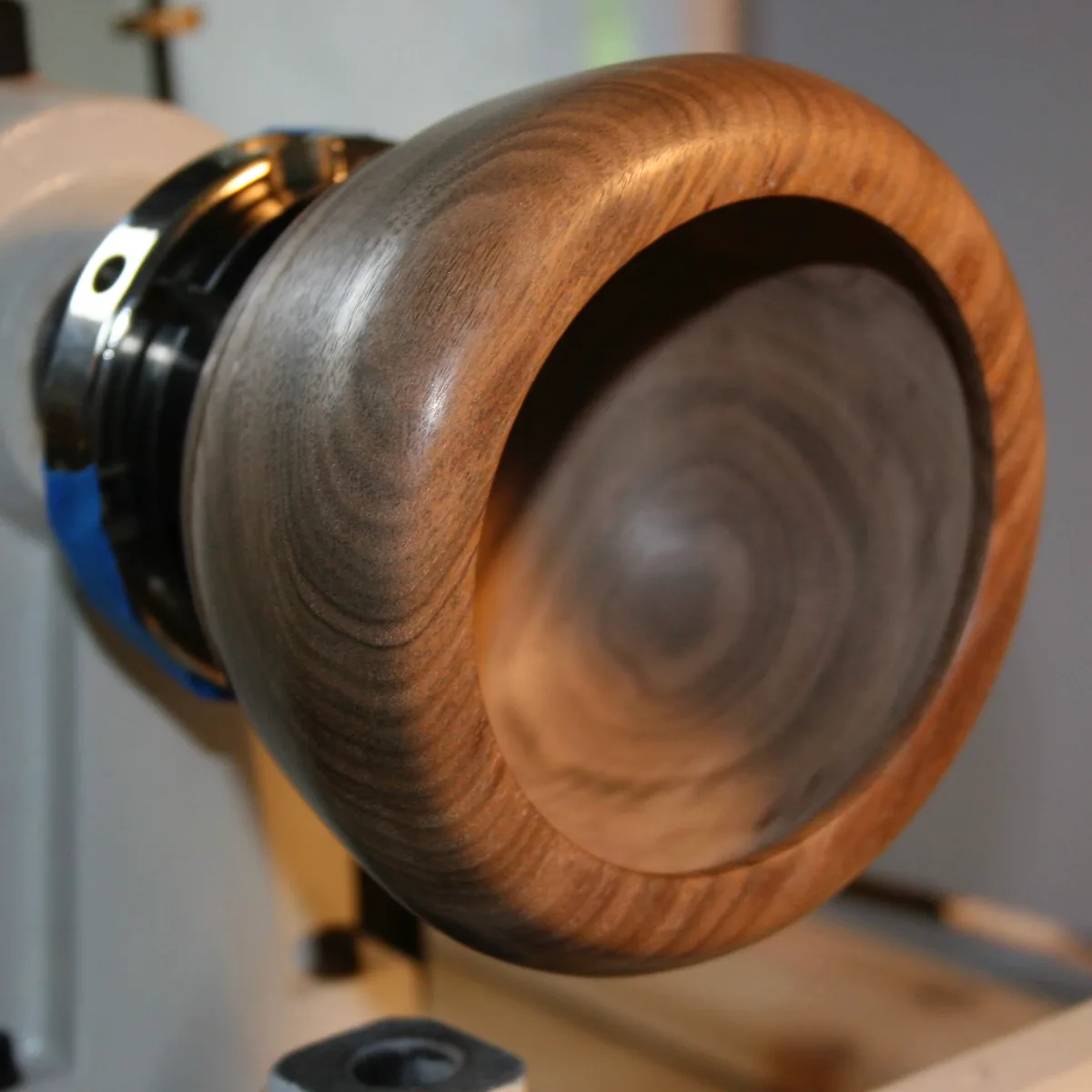 Hollowed walnut bowl on the lathe showing the interior taking shape