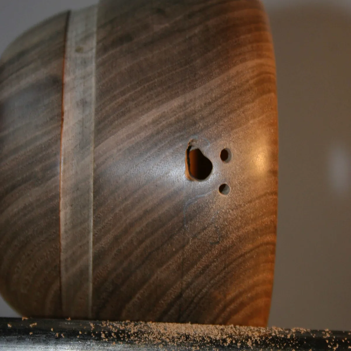 Walnut bowl on the lathe with the first drilled holes started