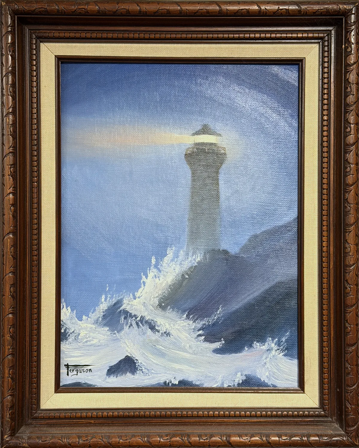 Framed oil painting of a lighthouse with waves crashing against rocks