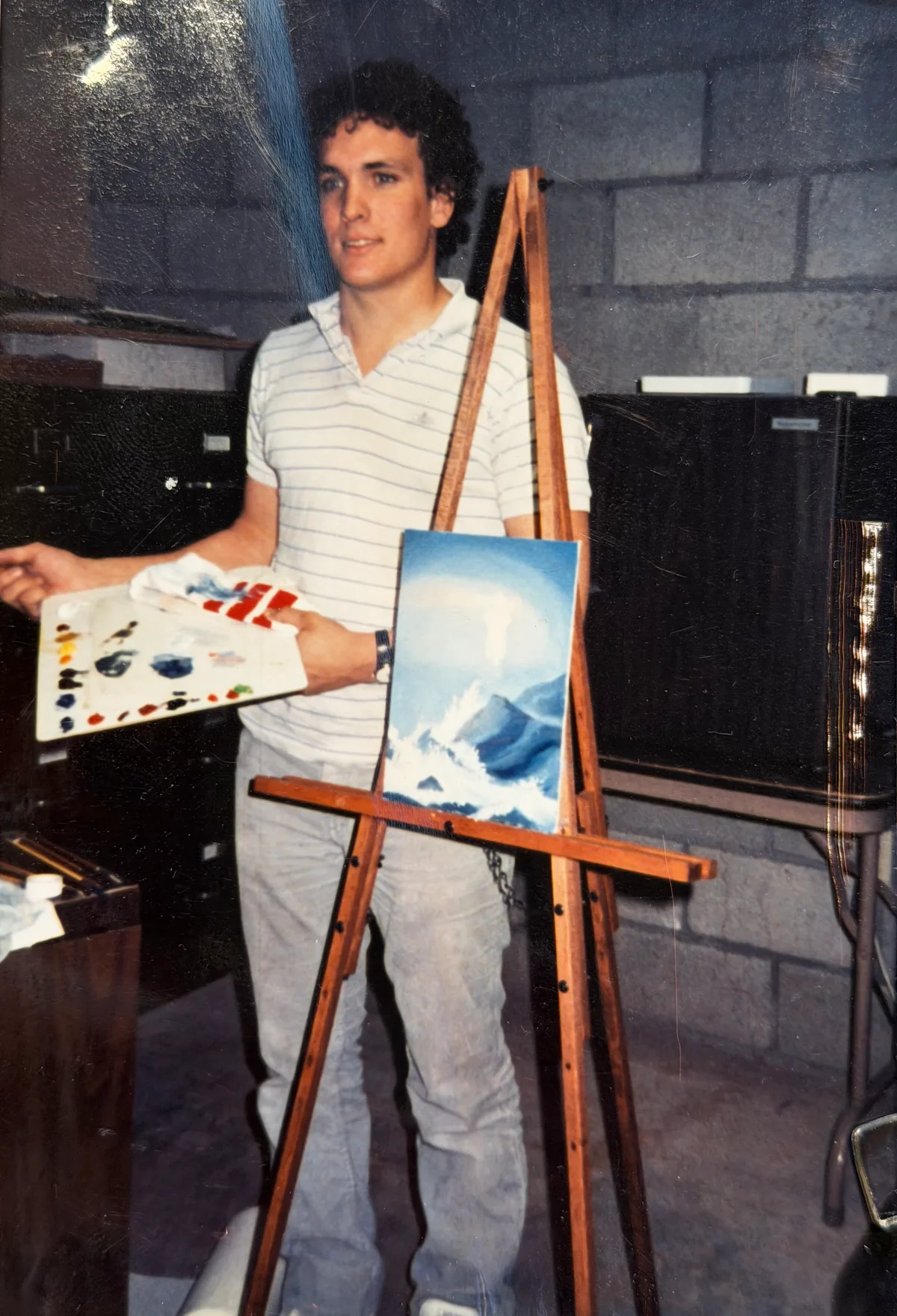 Thad standing beside an easel with the lighthouse painting in progress