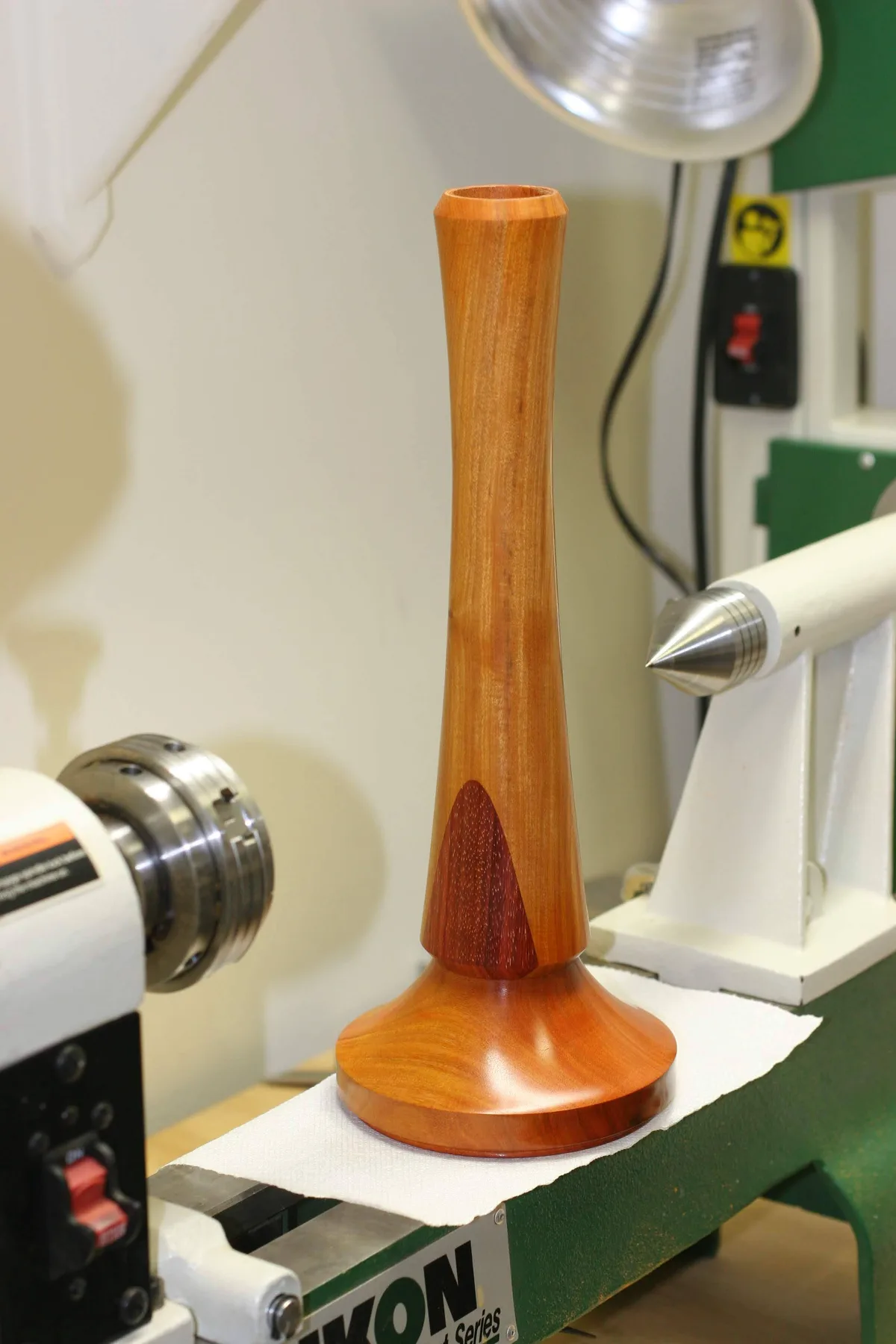 Finished wood lamp stand with a waisted column and triangular color patch